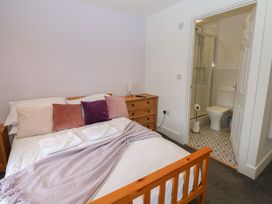 A bedroom with a bed and adjoining bathroom at Salvin Cottage in Alston