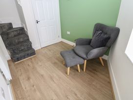 A hallway with a chair and footrest at Salvin Cottage in Alston