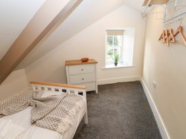 A bedroom with a bed and dresser at Salvin Cottage in Alston