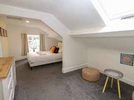 A bedroom with a bed and a table at Salvin Cottage in Alston