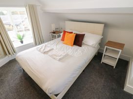 A bedroom with a bed and nightstand at Salvin Cottage in Alston