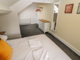 A bedroom with a bed and dresser at Salvin Cottage in Alston