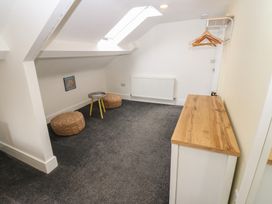 An attic room with a table and poufs at Salvin Cottage in Alston
