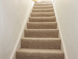 A staircase with carpet leading up at The Loft in Truro