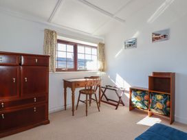 A bedroom with a window, desk, chair, and chest of drawers at The Loft in Probus