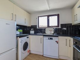 A kitchen with appliances including a fridge dishwasher and washing machine at The Loft in Probus