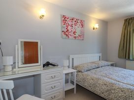 A bedroom with a bed and desk at The Loft in Probus