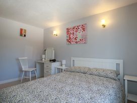 A bedroom with a bed, nightstand, chair and desk at The Loft in Probus