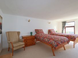 A bedroom with two single beds and a chair at The Loft in Probus