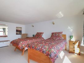 A bedroom with two beds and a lamp at The Loft in Probus