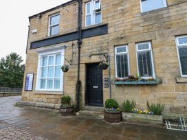 A front view of a stone building with a door and windows at The Railway Apartment in Hexham