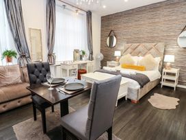 A studio apartment with a bed and dining table at The Railway Apartment in Hexham