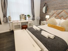 A bedroom with a bed, desk, and decorative items at The Railway Apartment in Hexham