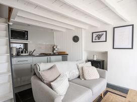 A living room with a kitchen unit and a sofa at The Ingle in Barmouth