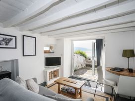 A living room with a sofa, television, and coffee table at The Ingle in Barmouth