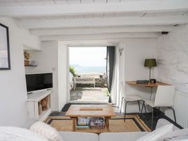 A living room with a sofa and table overlooking the sea at The Ingle in Barmouth