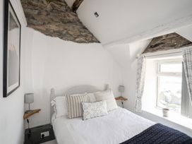 A bedroom with a bed and window at The Ingle in Barmouth