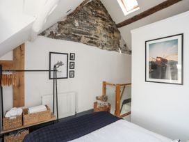 A bedroom with a clothes rack and photographs at The Ingle in Barmouth