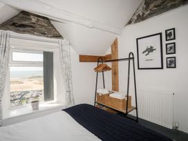 A bedroom with a window and shelf for towels at The Ingle in Barmouth