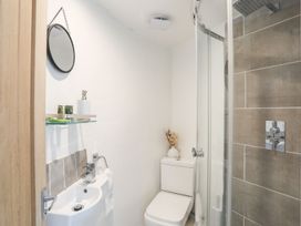 A bathroom with a sink, toilet, and shower at The Ingle in Barmouth