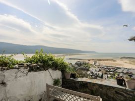 A coastal view with mountains and buildings at The Ingle in Barmouth