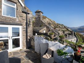 An outdoor area with a stone house and patio furniture at The Ingle in Barmouth