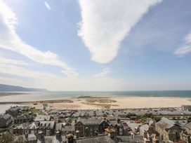 A view of a beach and parking area at The Ingle in Barmouth
