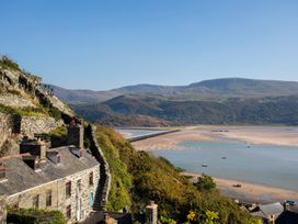 A view of houses and water with mountains in the background at The Ingle in Barmouth