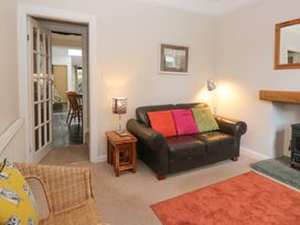 A living room with a sofa and lamp at Cloud Cottage in Ambleside