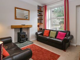 A living room with a fireplace and bookshelf at Cloud Cottage in Ambleside