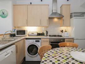 A kitchen with appliances and a round table at Cloud Cottage in Ambleside