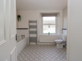 A bathroom with a bathtub, toilet, and window at Cloud Cottage in Ambleside
