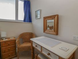 A bedroom with a chair and a table at Cloud Cottage in Ambleside