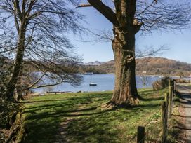 A view of a lake with a boat and mountains at Cloud Cottage Ambleside