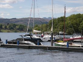 Boats on a dock in a lake with mountains in the background at Cloud Cottage Ambleside