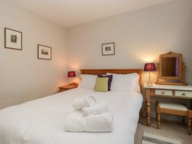 A bedroom with a bed and lamp at Cloud Cottage in Ambleside