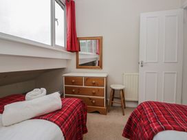 A bedroom with two beds and a mirror at Cloud Cottage in Ambleside