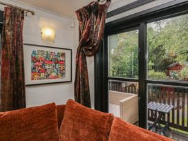 A living room with a window and couch at Moon Cottage near White Cross Bay Holiday Park near Troutbeck Bridge