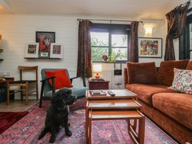 A living room with a dog sitting on the floor at Moon Cottage in White Cross Bay Holiday Park near Troutbeck Bridge
