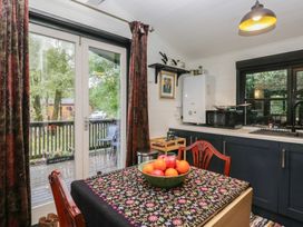 A kitchen with a table and fruit bowl at Moon Cottage in White Cross Bay Holiday Park near Troutbeck Bridge