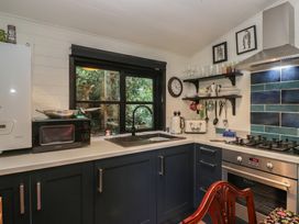 A kitchen with appliances and a window at Moon Cottage in White Cross Bay Holiday Park near Troutbeck Bridge