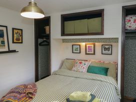 A bedroom with a bed and wall art at Moon Cottage near White Cross Bay Holiday Park near Troutbeck Bridge