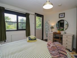 A bedroom with a bed and desk at Moon Cottage near White Cross Bay Holiday Park near Troutbeck Bridge