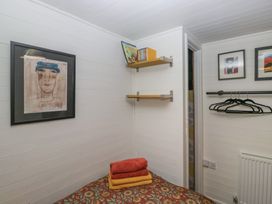 A bedroom with shelves and towels at Moon Cottage White Cross Bay Holiday Park near Troutbeck Bridge