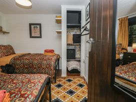 A bedroom with two beds and a closet at Moon Cottage near White Cross Bay Holiday Park near Troutbeck Bridge