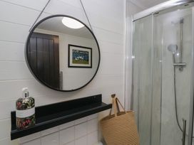 A bathroom with a mirror and shower at Moon Cottage White Cross Bay Holiday Park near Troutbeck Bridge