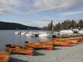 A scene with boats at a dock near the water at Moon Cottage White Cross Bay Holiday Park near Troutbeck Bridge