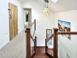 A hallway with a staircase and door at Hen Stablau in Corwen