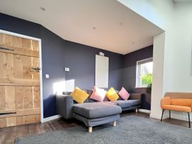 A living room with a sofa and a door at Hen Stablau Dinmael near Cerrigydrudion
