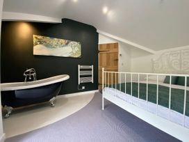 A bedroom with a bed and bathtub at Hen Stablau Dinmael near Cerrigydrudion